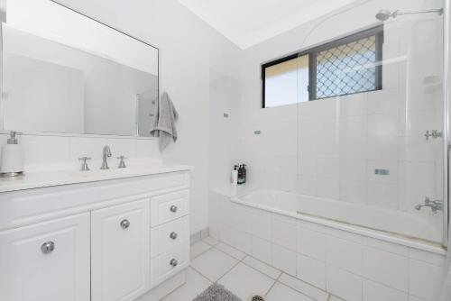 uma casa de banho branca com uma banheira e um lavatório em 3 bedroom home em Ross River