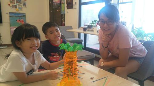 a woman and two children sitting at a table at Have FUN villa in Hengchun