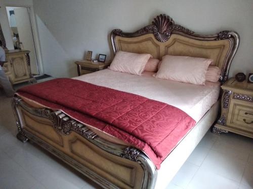 a bedroom with a large bed with a wooden frame at Narahma Homestay in Bukittinggi