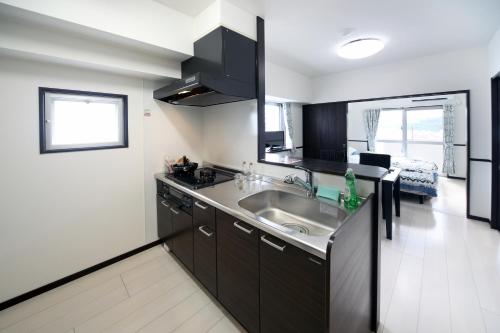 una cucina con lavandino e piano di lavoro di EX Itoman Apartment 701 a Itoman