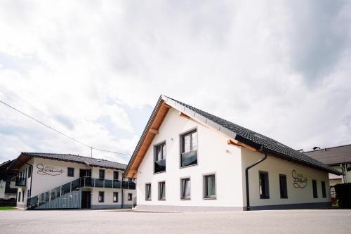 a white building with a black roof at Apartmenthaus Strasswirt De Luxe in Tröpolach