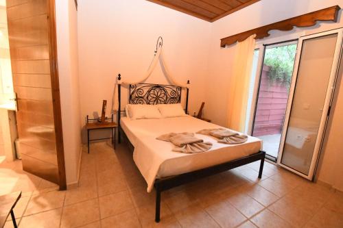 a bedroom with a bed and a large window at Ktima Kallitero Villas in Argassi
