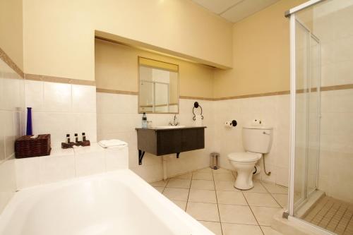 Ett badrum på Benvenuto Hotel & Conference Centre