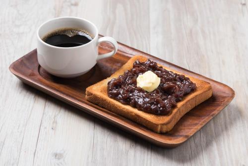 a plate with a piece of bread and a cup of coffee at Hotel Mystays Nagoya Nishiki in Nagoya
