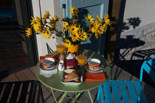- une table avec de la nourriture et des boissons ainsi qu'un vase avec des fleurs dans l'établissement D'un jour à l'autre, à Banassac
