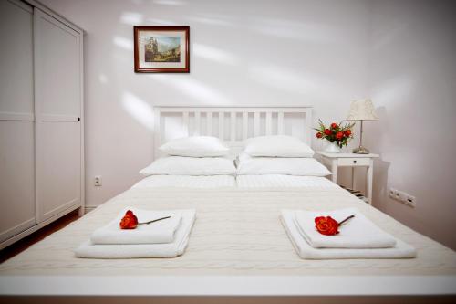 Una cama blanca con dos rosas rojas encima. en Mariensztat / Old Town Place for You, en Varsovia