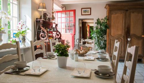 - une table avec des assiettes et des ustensiles en haut dans l'établissement Au Jardin D'Eloïse, à Tréméreuc