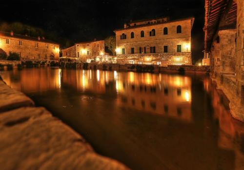 a view of a river at night with buildings at RELAIS VAL D'ORCIA in Pienza
