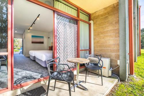 a patio with a table and chairs and a bedroom at Nightcap at York on Lilydale in Mount Evelyn