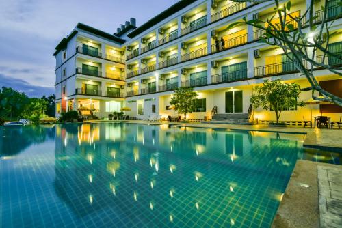 a hotel with a swimming pool in front of a building at Southgate Residence Hotel - SHA Certified in Chumphon