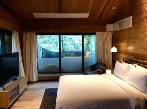 a bedroom with a bed and a large window at The Nook Hotel Hangzhou - A design hotel, 20 mins to West Lake and Lingyin Temple in Hangzhou