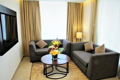 a living room with a couch and a table with flowers at Downtown Hotel Apartments in Amman