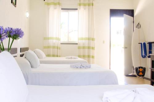 - 2 lits blancs dans une chambre avec fenêtre dans l'établissement Bungalows Zicatela, à Puerto Escondido