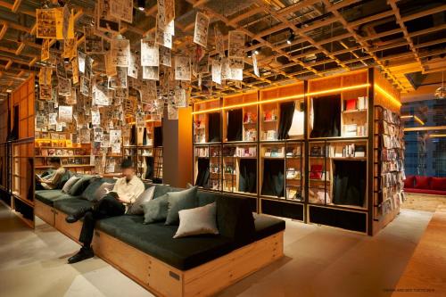 a living room filled with furniture and a large window at Book And Bed Tokyo Shinjuku in Tokyo