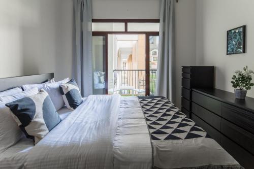 1 dormitorio con 1 cama grande y balcón en Frank Porter - Fortunato en Dubái