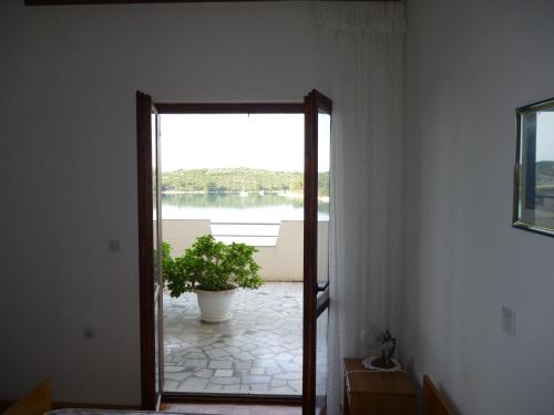 a door leading to a patio with a potted plant at Picić Guesthouse in Luka