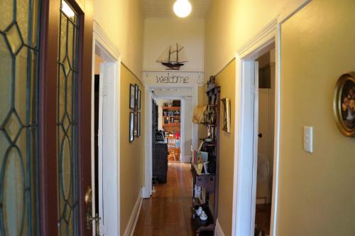a hallway with yellow walls and a door with a ship on the wall at Delightful Cottage in Queenscliff
