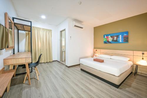 a hotel room with a bed and a desk at Northern Lodge Hotel in Sungai Petani