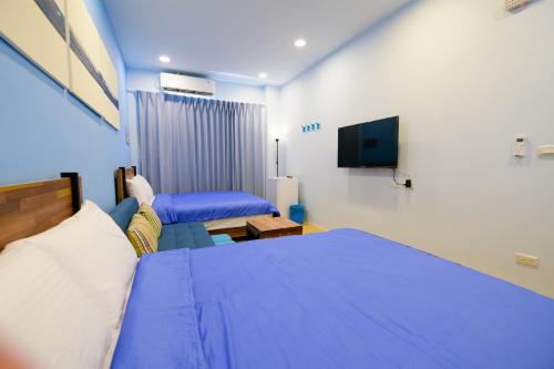 a hotel room with two beds and a tv at 夏海民宿 in Magong