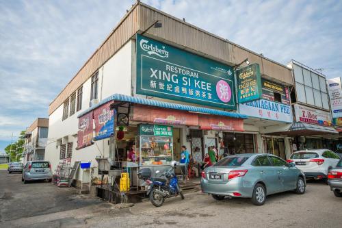a street with cars parked in front of a building at Northern Lodge Hotel in Sungai Petani