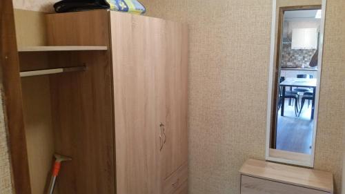 a wooden cabinet in a room with a table at Vasarnamis Zarasuose in Zarasai