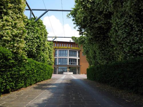 an empty road in front of a building with bushes at Pilgrim's Hotel in Cicognolo