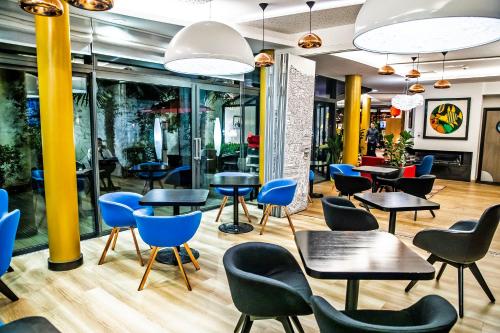 ein Restaurant mit blauen Stühlen und Tischen in einer Cafeteria in der Unterkunft Hôtel Hor Europe in Paris
