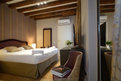 ein Hotelzimmer mit einem Bett und einem Stuhl in der Unterkunft Residence La Fenice in Venedig