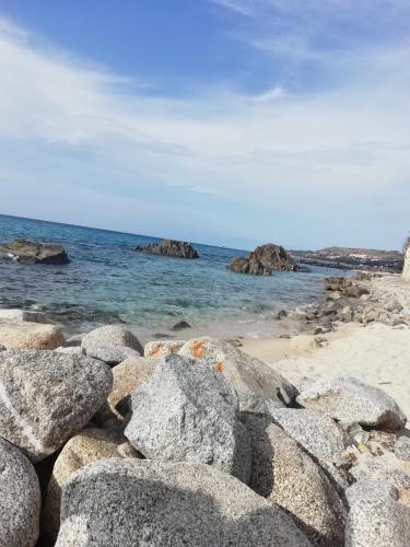 a group of rocks on a beach with the ocean at Residenza Villa Spagnola in Parghelia