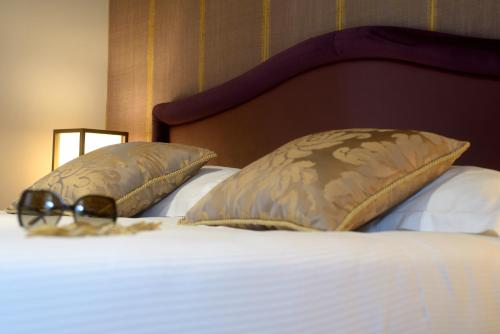 a bed with two pillows on top of it at Residence La Fenice in Venice