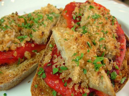 a white plate with two pieces of bread with tomatoes at Locanda Il Gallo in Greve in Chianti