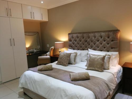 a bedroom with a large bed with two pillows at Pongola Road Self Catering Accommodation in Uitenhage
