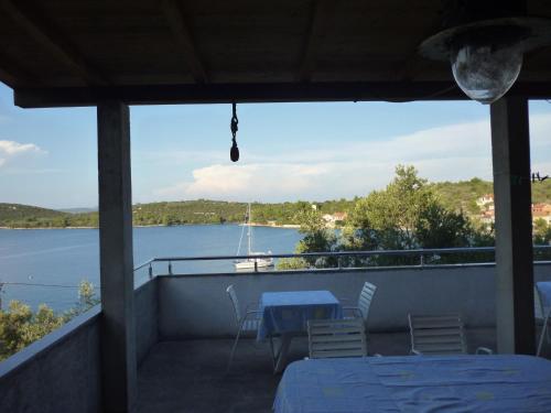 a balcony with a table and chairs and a view of the water at Picić Guesthouse in Luka