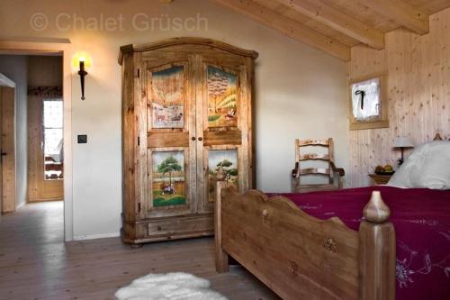 a bedroom with a large wooden cabinet and a bed at Chalet Grüsch in Grüsch