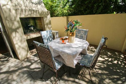 una mesa con sillas y flores en un patio en The Luxury Loft, en Montagu