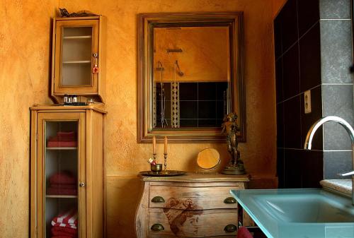 a bathroom with a sink and a mirror and a wooden dresser at Quinta Campo Bravo in Oliveira do Hospital