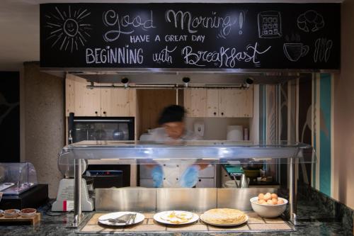 une personne dans une cuisine préparant des aliments derrière un comptoir dans l'établissement Catalonia Eixample 1864, à Barcelone