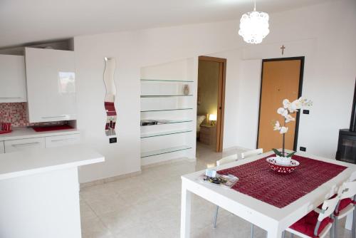 a white kitchen with a white table and a dining room at Via del Mare in Lanciano