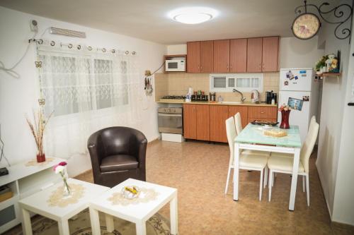 a kitchen with two tables and a refrigerator at Master hosting Gal in Bet Sheʼan