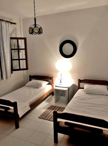 a bedroom with two beds and a lamp and a mirror at Ammouliani Captain's House in Ammouliani