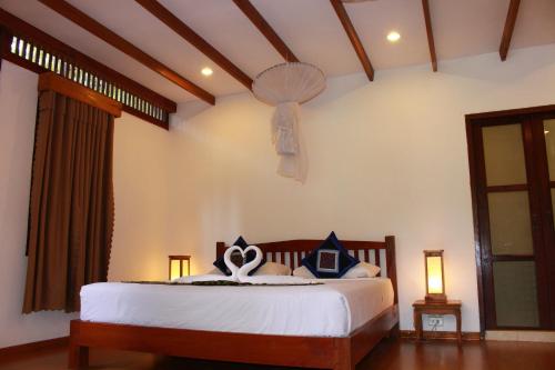 a bedroom with a bed and a chandelier at Tadlo Lodge in Ban Nongtoung