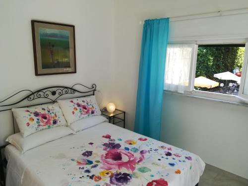 Un dormitorio con una cama con flores. en Home by the Sea (Rainbow Home), en Monterosso al Mare