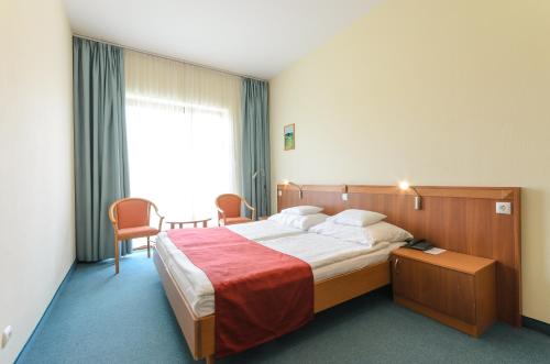 a hotel room with a large bed and a window at Hunguest Hotel Aqua Sol in Hajdúszoboszló