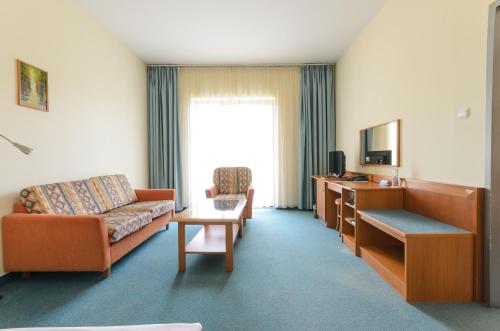 a living room with a couch and a table at Hunguest Hotel Aqua Sol in Hajdúszoboszló