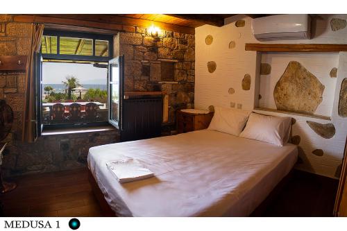 a bedroom with a large bed in a room with a window at Medusa Gorgon in Develíkia