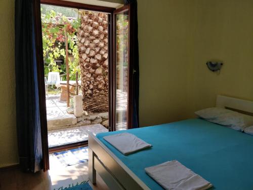 Schlafzimmer mit einem Bett und einer Tür zu einer Terrasse in der Unterkunft Apartments Jovic in Mali Lošinj