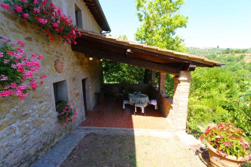 a patio of a house with a table and flowers at Villa Gioiosa in Monte San Savino