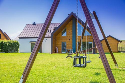 a swing set in front of a house at Jaśminowy Sad in Mikołajki