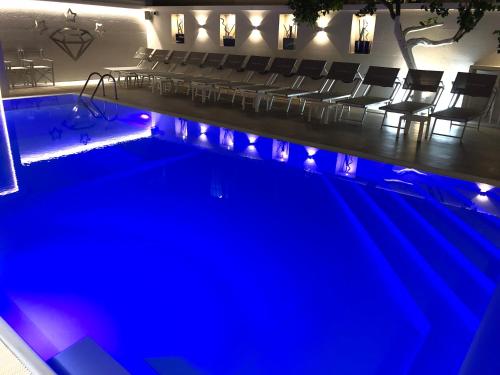 a swimming pool with chairs and an auditorium at Hotel Smeraldo in Qualiano