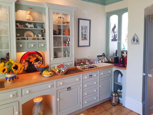 a kitchen with white cabinets and a counter top at Alma House Bed and Breakfast in Newbury